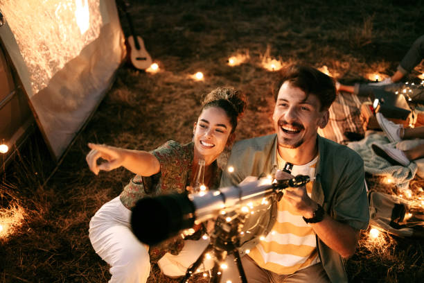 couple stargazing with a telescope